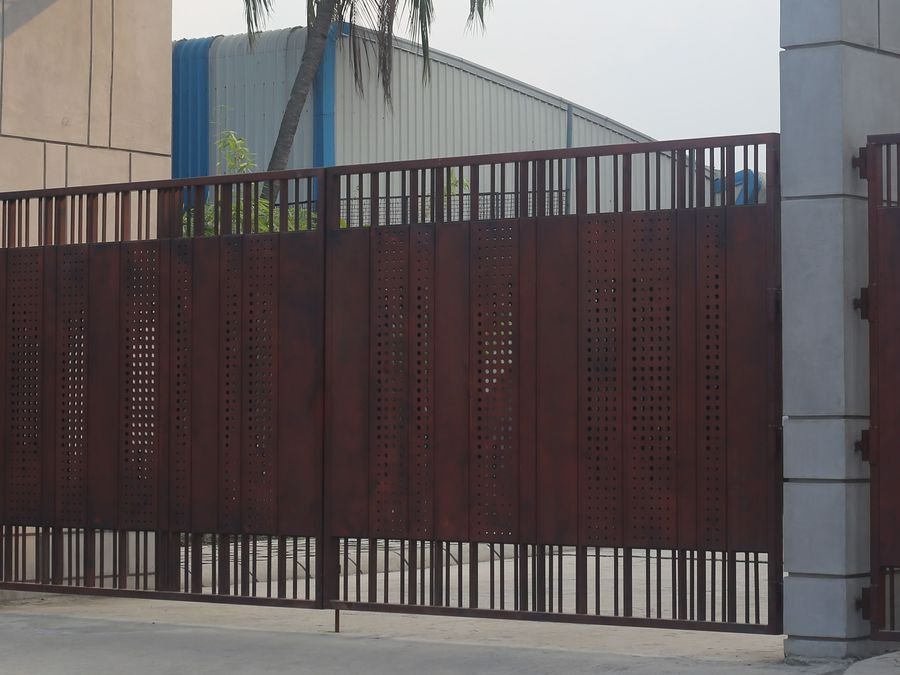 Fabricated MS main gate with vertical bar infill at a compound entrance